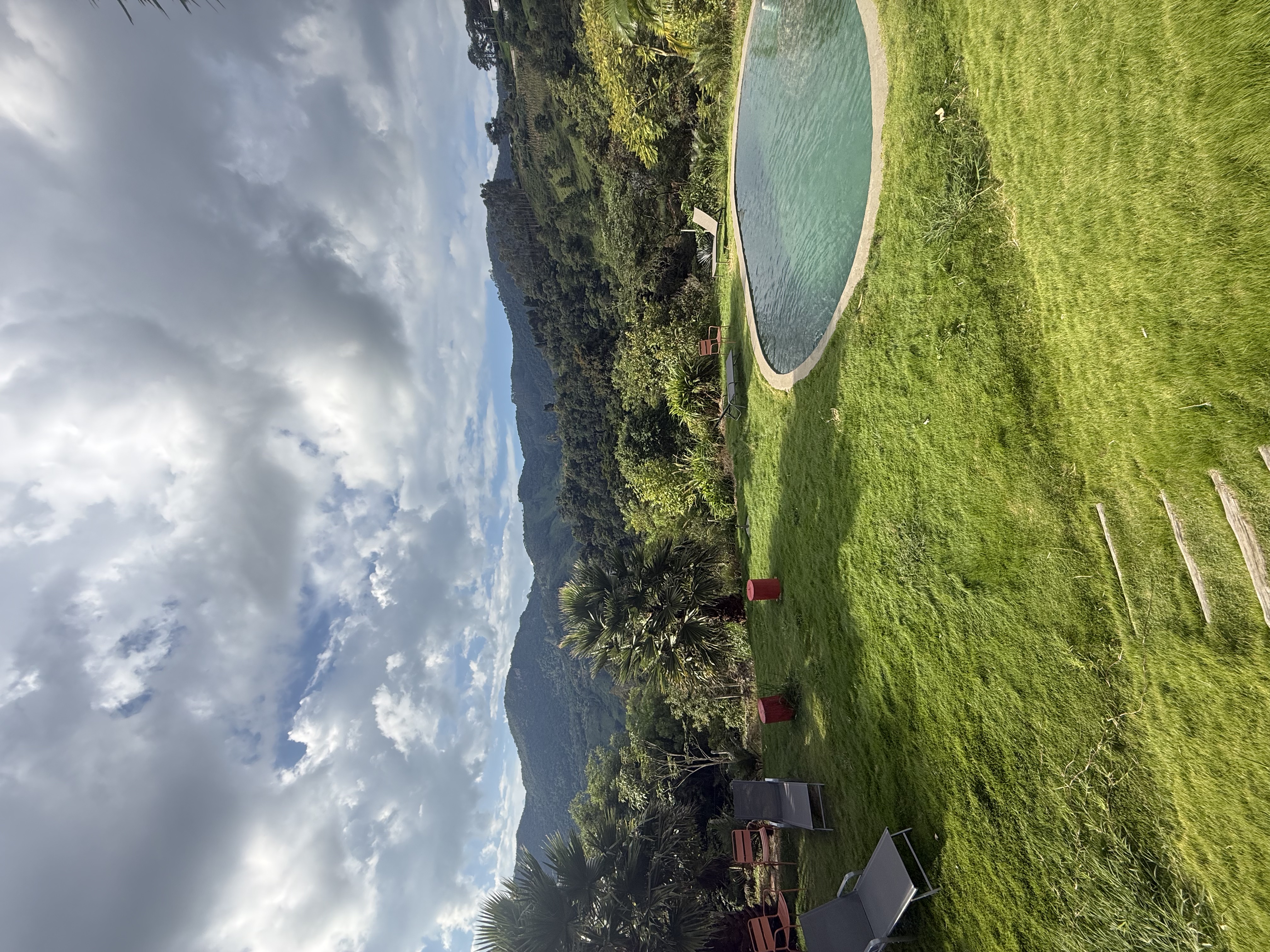 Chalé de madeira com montanhas ao fundo e pôr do sol dourado